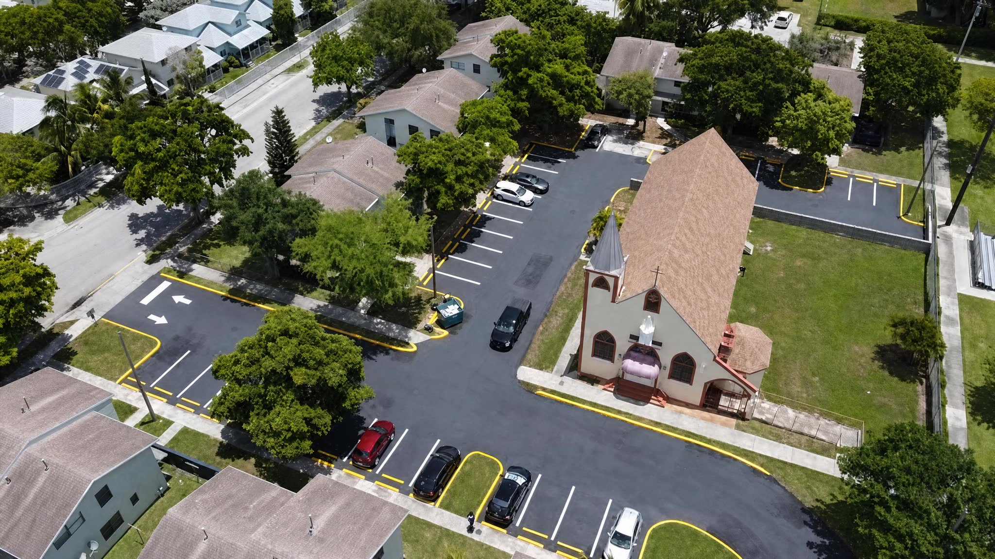 Aerial view of a church campus with brand-new asphalt parking and fresh markings